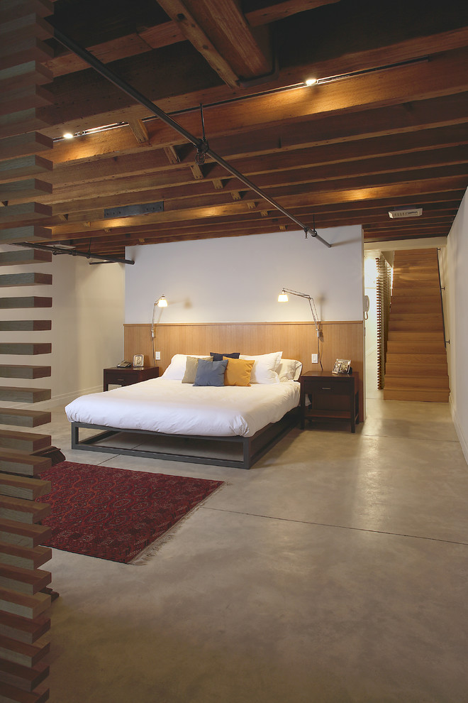 Industrial bedroom in New York with concrete floors.