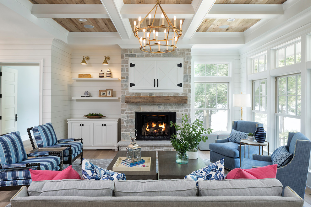 Inspiration for a beach style living room in Minneapolis with white walls, a standard fireplace, a stone fireplace surround and a concealed tv.