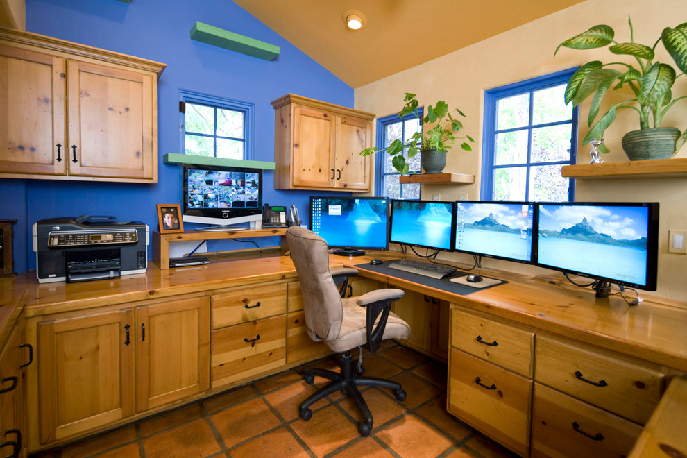 Design ideas for an eclectic study room in Santa Barbara with blue walls, terra-cotta floors and a built-in desk.