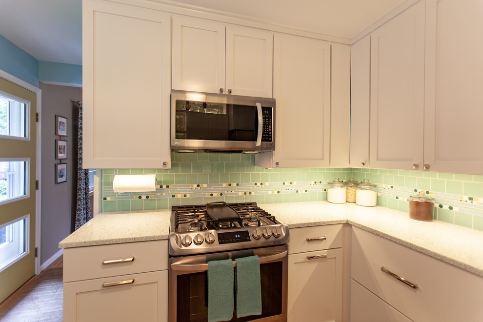 Midcentury separate kitchen in Minneapolis with an undermount sink, shaker cabinets, white cabinets, recycled glass benchtops, green splashback, mosaic tile splashback, stainless steel appliances, medium hardwood floors, no island, brown floor and white benchtop.