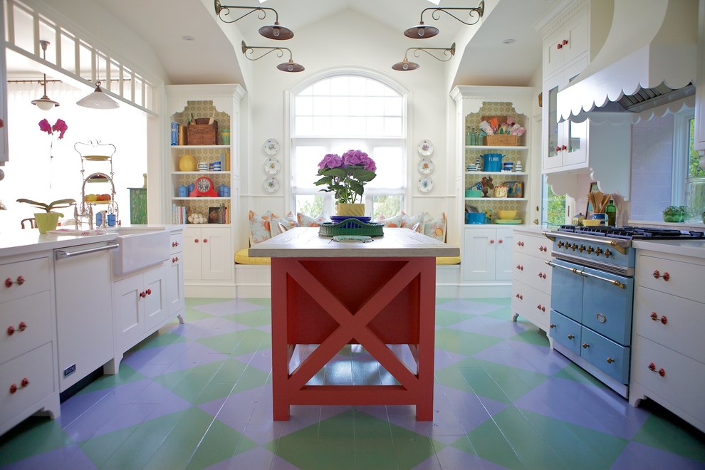 Inspiration for a beach style kitchen in Los Angeles with a farmhouse sink, white cabinets, quartz benchtops, ceramic splashback, painted wood floors, with island, coloured appliances and multi-coloured floor.
