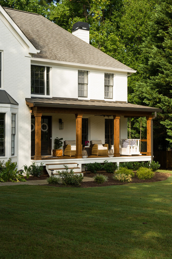 This is an example of a transitional front yard verandah in Atlanta with with columns, decking and a roof extension.