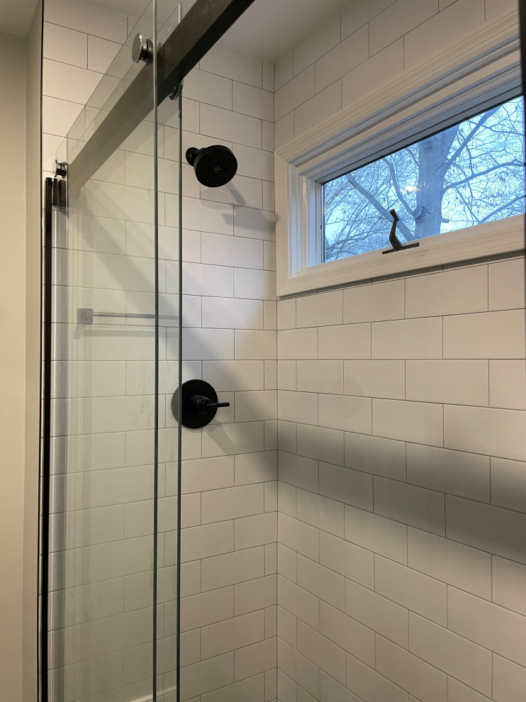 Medium sized modern ensuite bathroom in DC Metro with flat-panel cabinets, brown cabinets, an alcove shower, white tiles, porcelain tiles, grey walls, porcelain flooring, a submerged sink, granite worktops, black floors, a sliding door, black worktops, a shower bench, double sinks and a floating vanity unit.