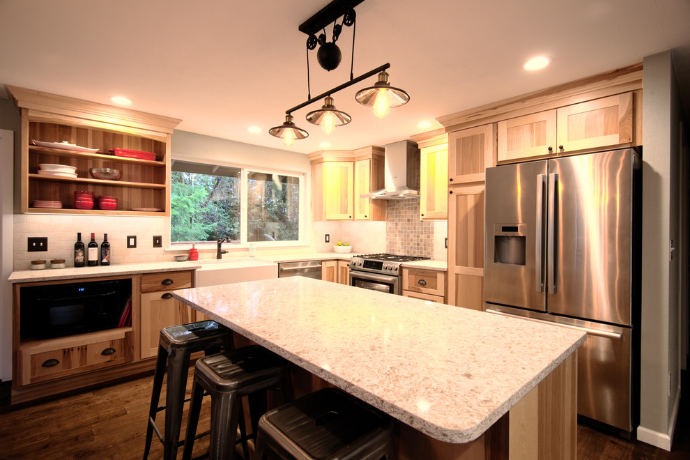 Mid-sized mountain style l-shaped medium tone wood floor eat-in kitchen photo in Seattle with a farmhouse sink, shaker cabinets, light wood cabinets, quartz countertops, beige backsplash, stone tile backsplash, stainless steel appliances and an island
