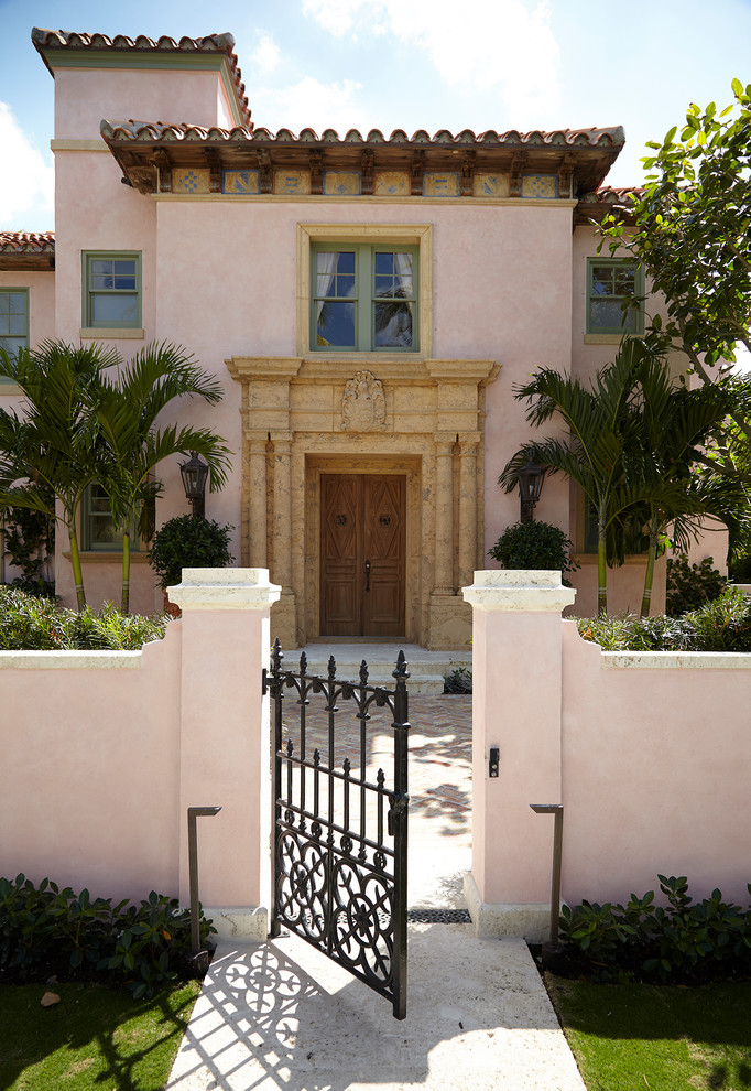 Mediterranean front door in Miami with pink walls, a double front door, a medium wood front door and grey floor.