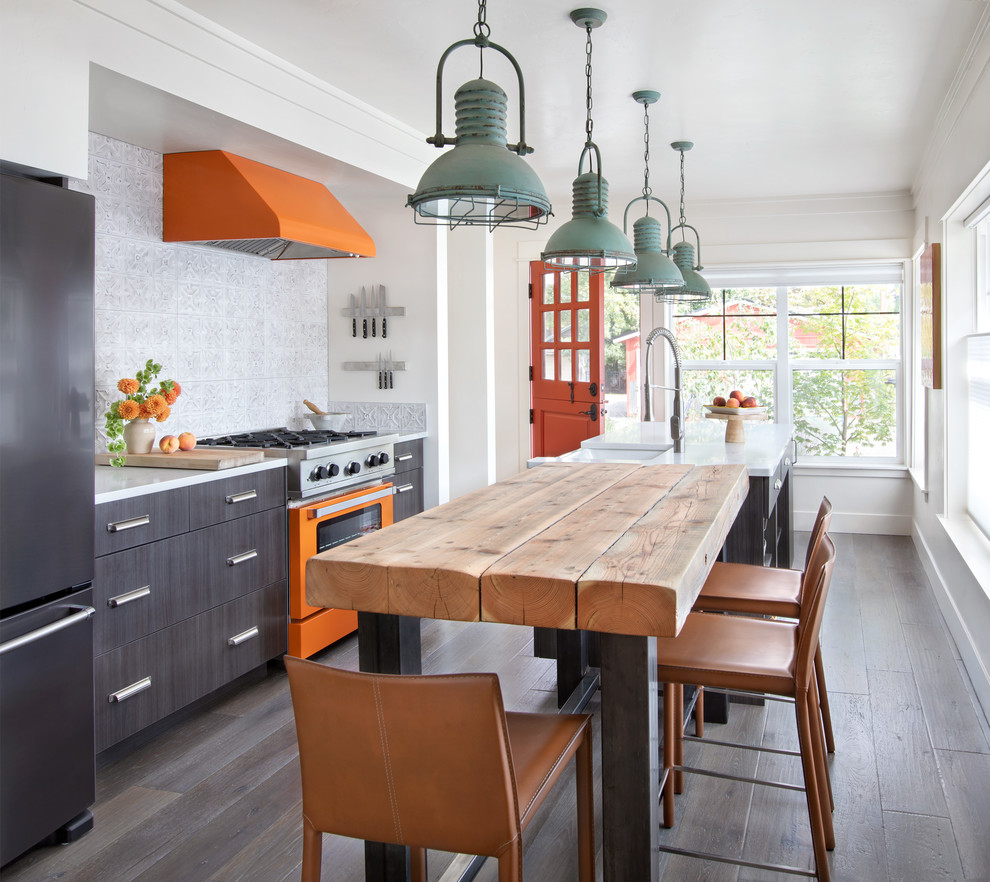 This is an example of a country kitchen in Other with flat-panel cabinets, marble benchtops, white splashback, coloured appliances, dark hardwood floors, white benchtop, a farmhouse sink, multiple islands and brown floor.