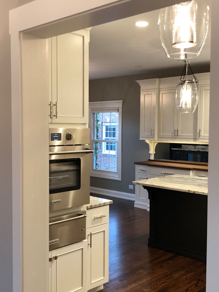 Inspiration for a transitional eat-in kitchen remodel in Chicago with white backsplash, stainless steel appliances and an island