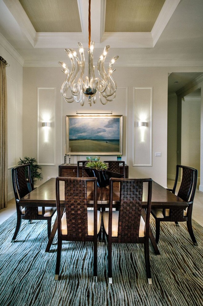 Example of a large transitional travertine floor and beige floor enclosed dining room design in Miami with beige walls and no fireplace