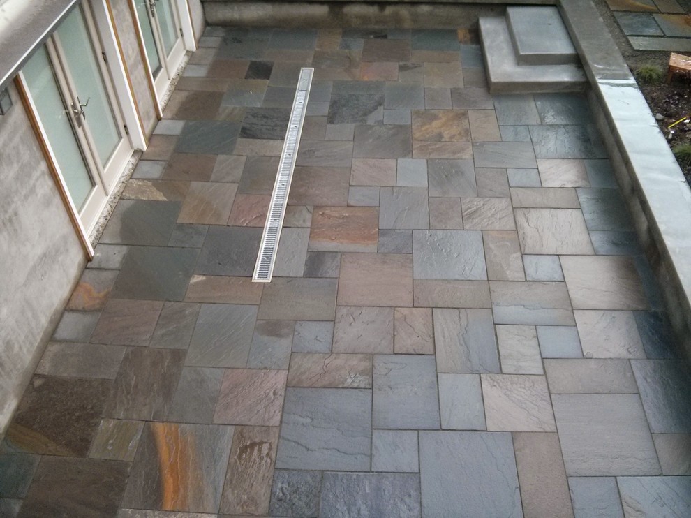 Photo of a contemporary courtyard patio in Seattle with natural stone pavers and no cover.