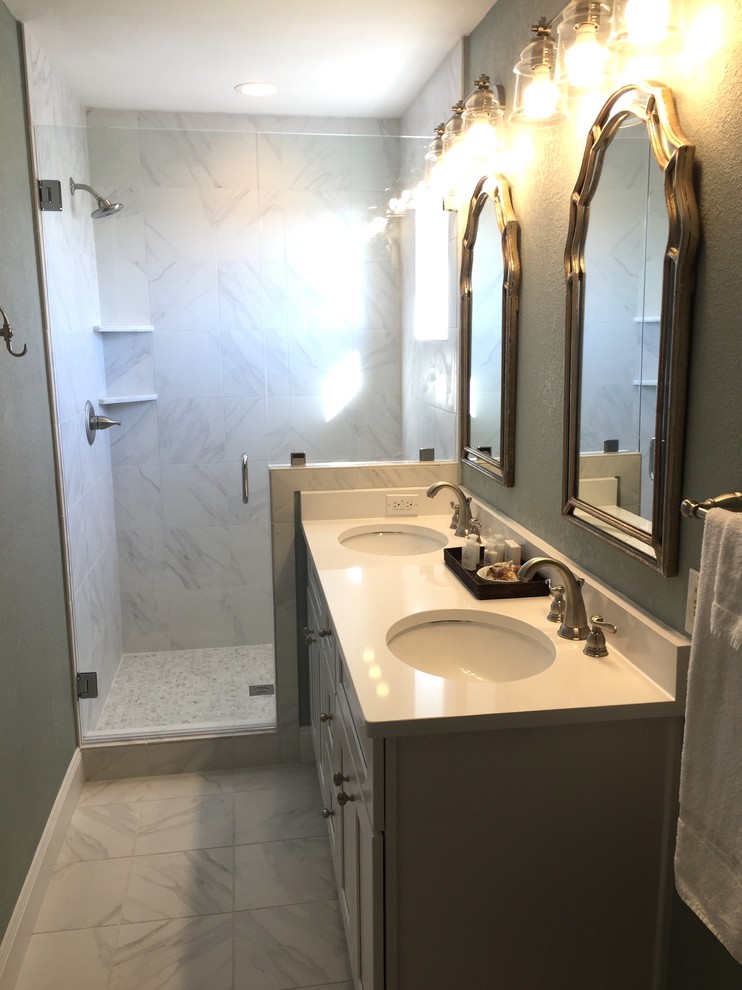This is an example of a mid-sized beach style master bathroom in Miami with shaker cabinets, white cabinets, an open shower, a one-piece toilet, white tile, porcelain tile, blue walls, porcelain floors, an undermount sink and engineered quartz benchtops.