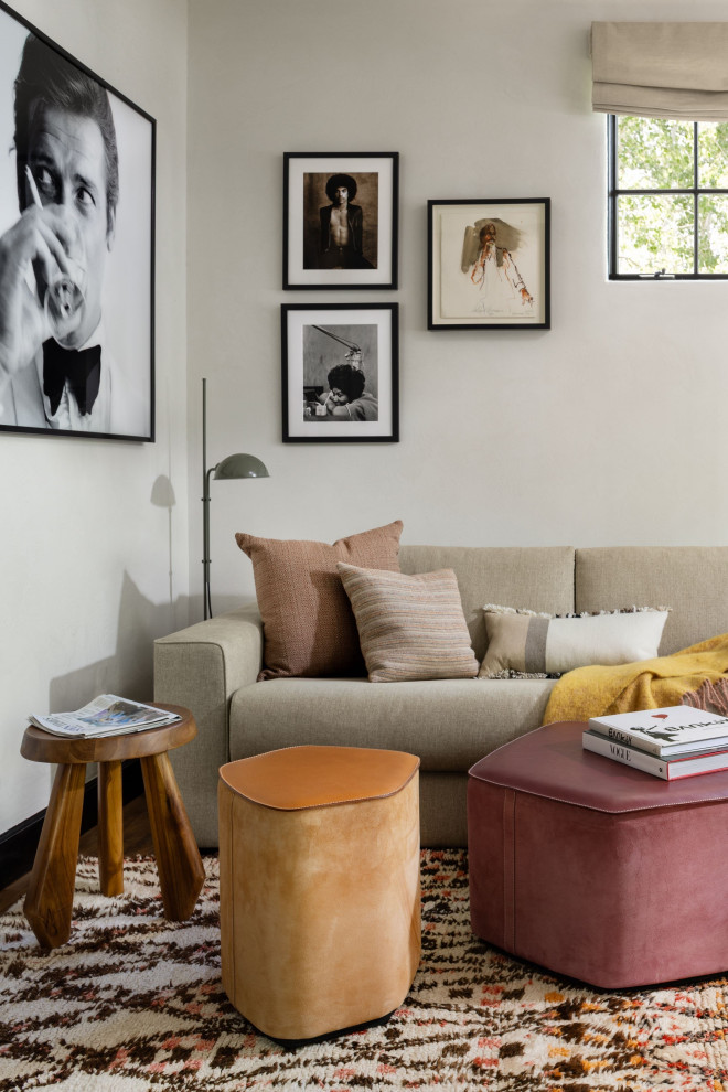 Cette image montre un salon minimaliste de taille moyenne et fermé avec une salle de réception, un sol en bois brun, une cheminée standard, un manteau de cheminée en métal, un téléviseur fixé au mur, un mur blanc et un sol marron.