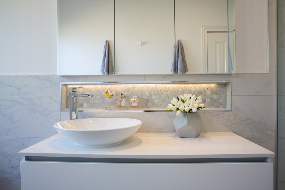 Mid-sized contemporary 3/4 bathroom in Melbourne with raised-panel cabinets, white cabinets, gray tile, porcelain tile, white walls, porcelain floors, a vessel sink and engineered quartz benchtops.