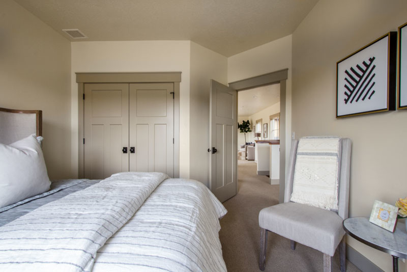 Large country guest bedroom in Salt Lake City with beige walls, carpet and no fireplace.