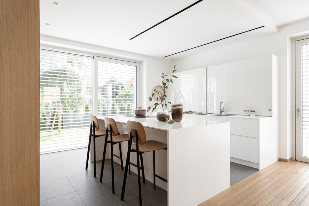 Design ideas for a small scandinavian galley eat-in kitchen in Other with a single-bowl sink, flat-panel cabinets, white cabinets, solid surface benchtops, porcelain floors, with island, grey floor, white benchtop and recessed.