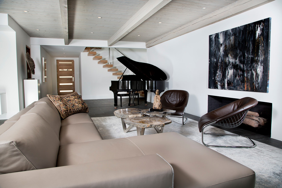 This is an example of a contemporary living room in Orange County with white walls, a standard fireplace and grey floor.