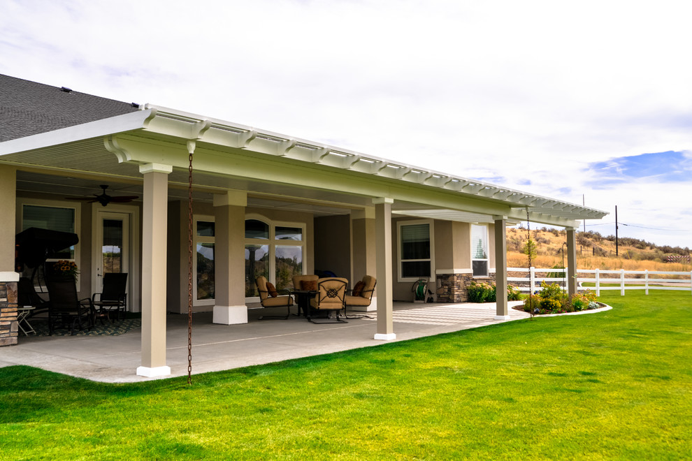 Patio - large transitional backyard patio idea in Boise with a roof extension