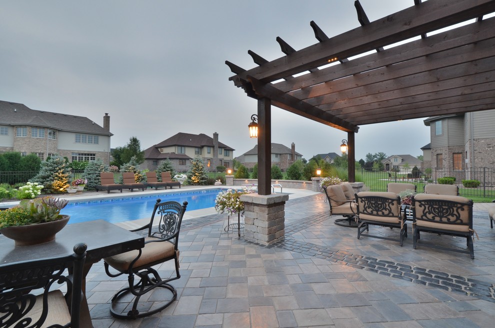 Photo of a large eclectic backyard patio in Chicago with a fire feature, concrete pavers and a pergola.