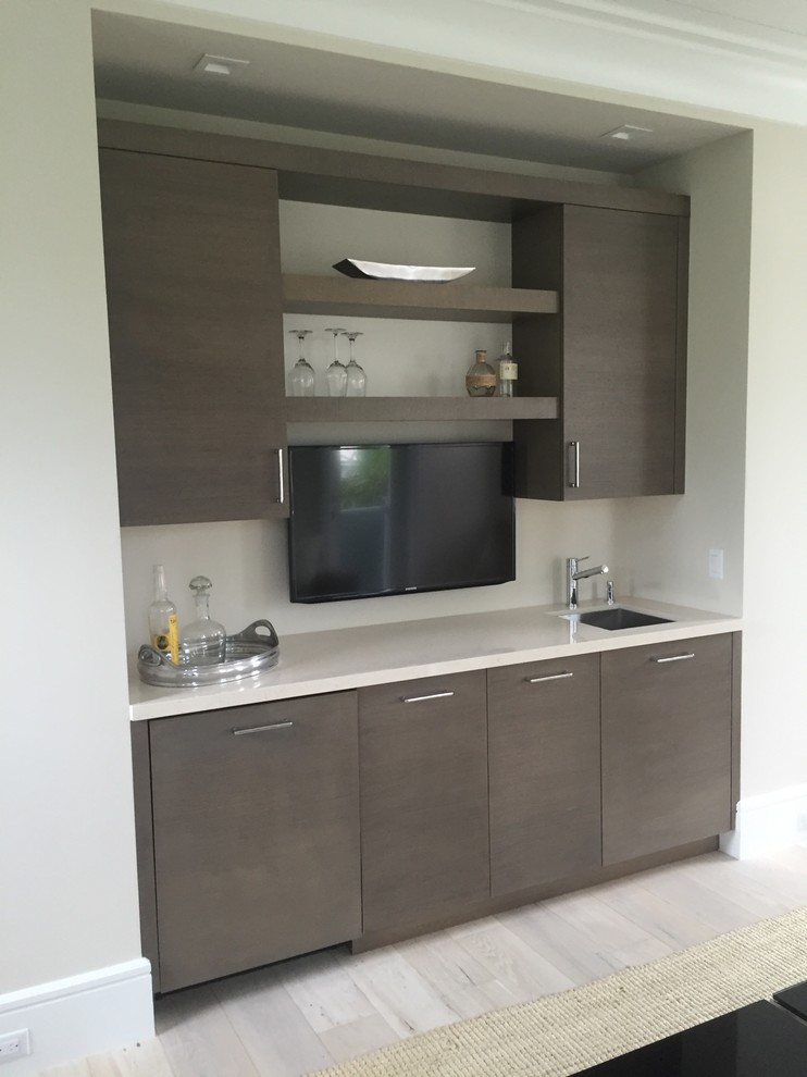 Inspiration for a mid-sized contemporary single-wall wet bar in Miami with an undermount sink, flat-panel cabinets, brown cabinets, quartz benchtops, light hardwood floors and grey floor.