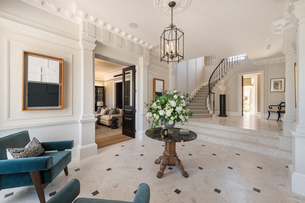 Design ideas for a large traditional foyer in London with white walls, marble floors and beige floor.