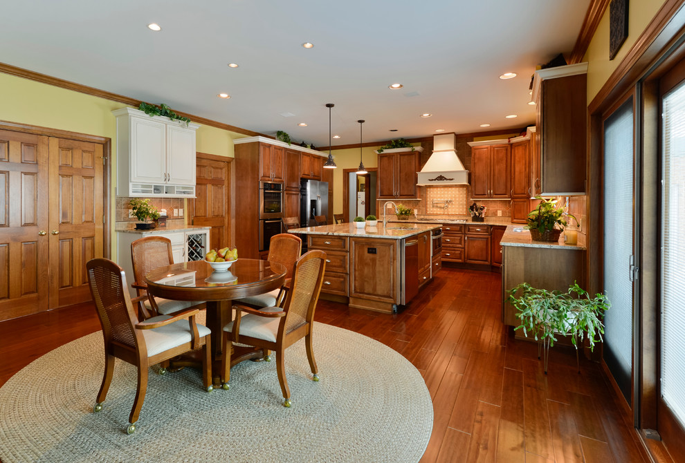Large transitional u-shaped medium tone wood floor eat-in kitchen photo with beaded inset cabinets, medium tone wood cabinets, granite countertops, beige backsplash, mosaic tile backsplash, stainless steel appliances and an island