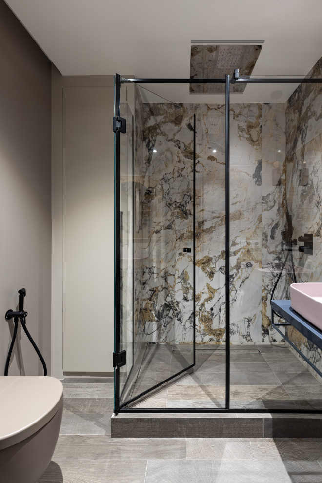 This is an example of a mid-sized contemporary powder room in Saint Petersburg with a wall-mount toilet, beige tile, porcelain tile, beige walls, ceramic floors, a vessel sink, solid surface benchtops, grey floor, blue benchtops and a floating vanity.