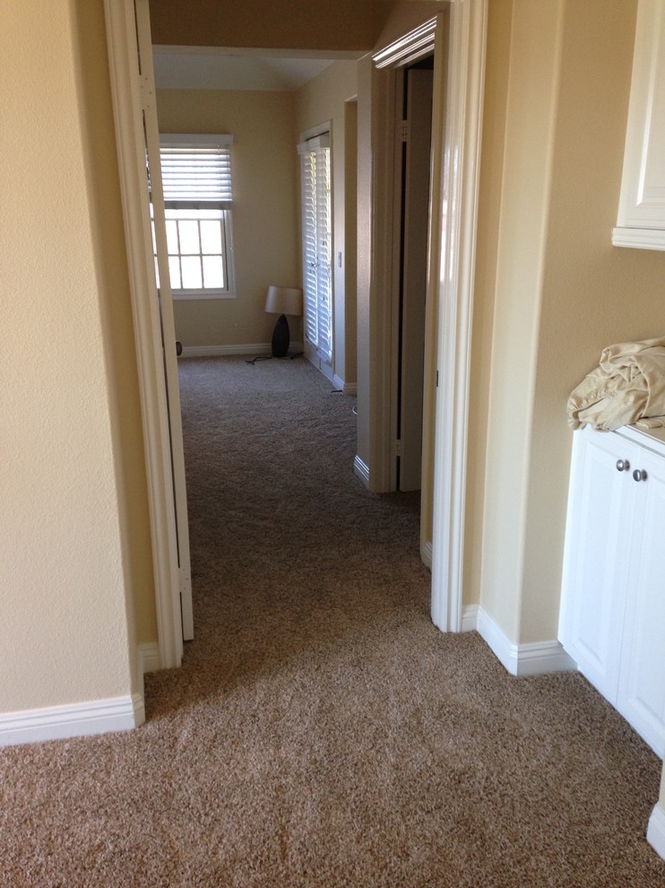 Design ideas for a mid-sized beach style hallway in Orange County with beige walls and carpet.