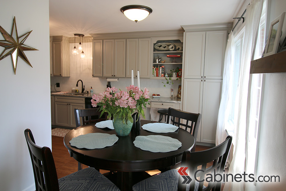 Inspiration for a transitional medium tone wood floor kitchen remodel in Tampa with a drop-in sink, flat-panel cabinets, gray cabinets, white backsplash, subway tile backsplash, stainless steel appliances and no island