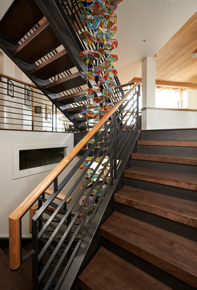 Large contemporary wood spiral staircase in Denver with wood risers and mixed railing.
