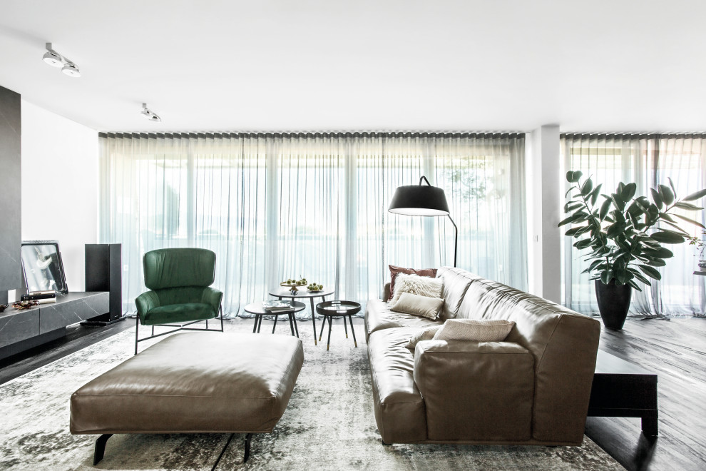 Esempio di un soggiorno contemporaneo aperto con pareti bianche, parquet scuro e pavimento nero