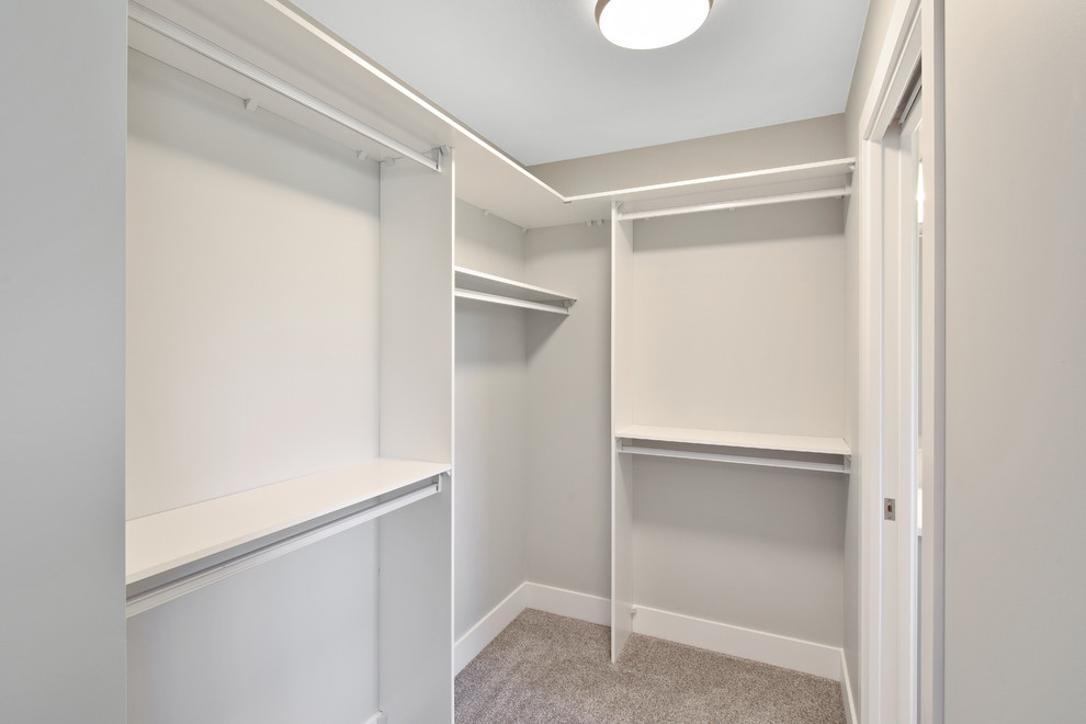 Design ideas for a small arts and crafts gender-neutral walk-in wardrobe in Other with open cabinets, white cabinets, carpet and grey floor.