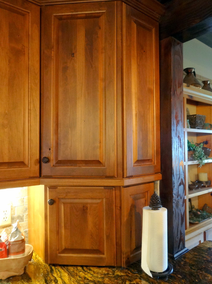 Example of a mid-sized mountain style l-shaped medium tone wood floor eat-in kitchen design in Charlotte with a farmhouse sink, raised-panel cabinets, dark wood cabinets, granite countertops, multicolored backsplash, stone tile backsplash, stainless steel appliances and an island