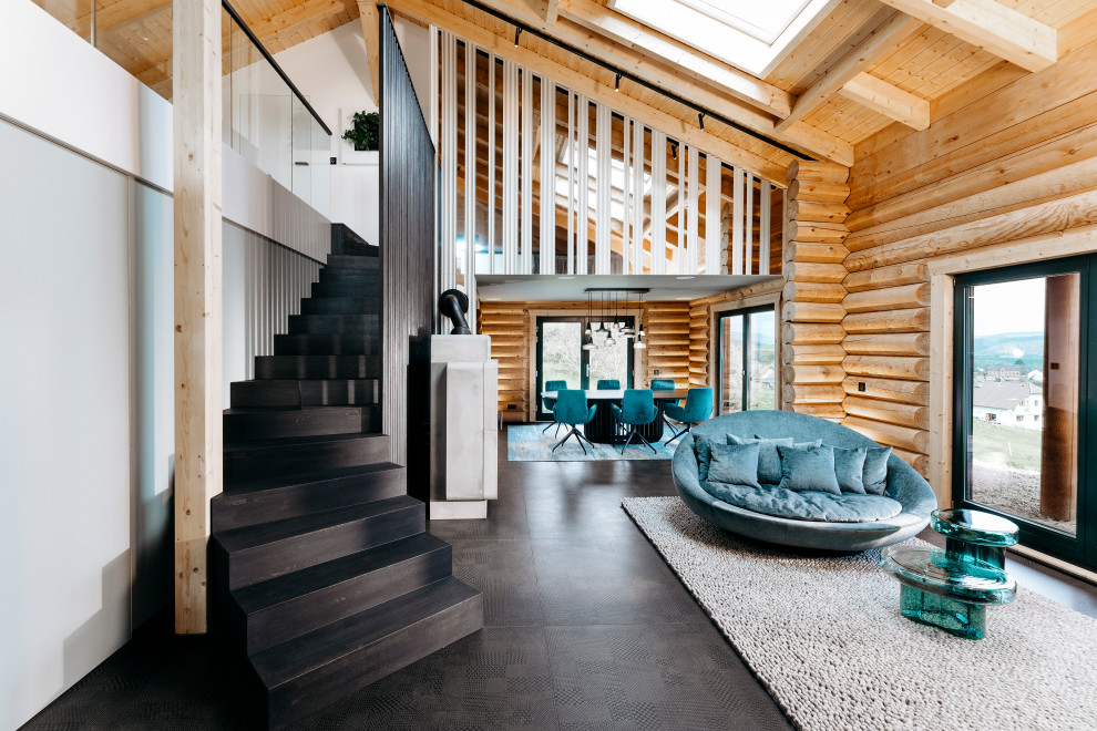 This is an example of a large contemporary formal open plan living room in Frankfurt with ceramic flooring, a wood burning stove, a concrete fireplace surround, a concealed tv, black floors, exposed beams and panelled walls.