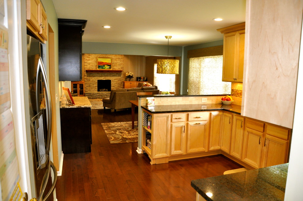 Inspiration for a mid-sized transitional u-shaped dark wood floor enclosed kitchen remodel in Cincinnati with an undermount sink, shaker cabinets, light wood cabinets, granite countertops, beige backsplash, stainless steel appliances and blue walls