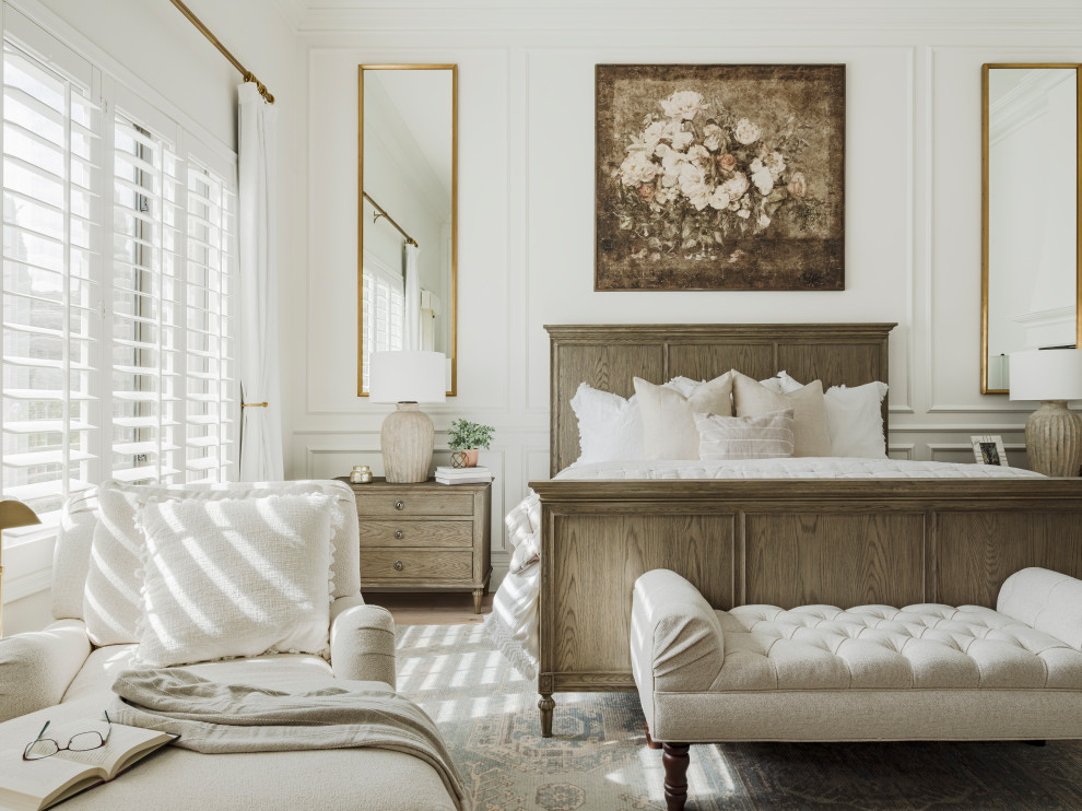 Diseño de dormitorio principal grande con paredes blancas, suelo de madera clara, chimenea de esquina, marco de chimenea de yeso, suelo gris, machihembrado y panelado