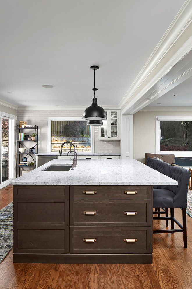 Inspiration for an u-shaped medium tone wood floor and brown floor eat-in kitchen remodel in Toronto with an undermount sink, shaker cabinets, dark wood cabinets, quartz countertops, white backsplash, subway tile backsplash, an island and gray countertops