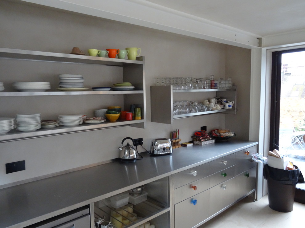 Foto de cocina contemporánea con encimera de acero inoxidable, electrodomésticos de acero inoxidable y puertas de armario en acero inoxidable