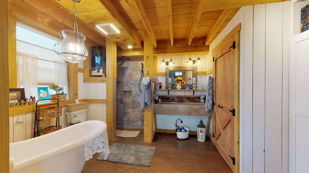 Mid-sized country master bathroom in New York with open cabinets, a claw-foot tub, an open shower, multi-coloured tile, concrete floors, an integrated sink, concrete benchtops, brown floor and brown benchtops.