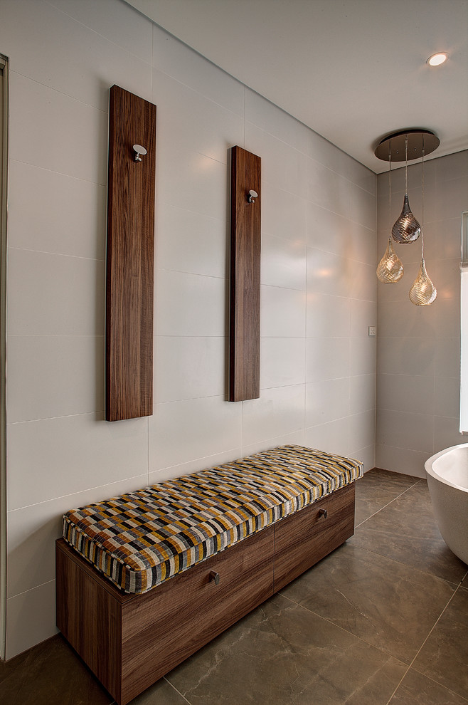 Modern inredning av ett stort en-suite badrum, med vita skåp, ett fristående badkar, brun kakel, ett integrerad handfat, en vägghängd toalettstol, porslinskakel, vita väggar, klinkergolv i porslin och bänkskiva i kvarts