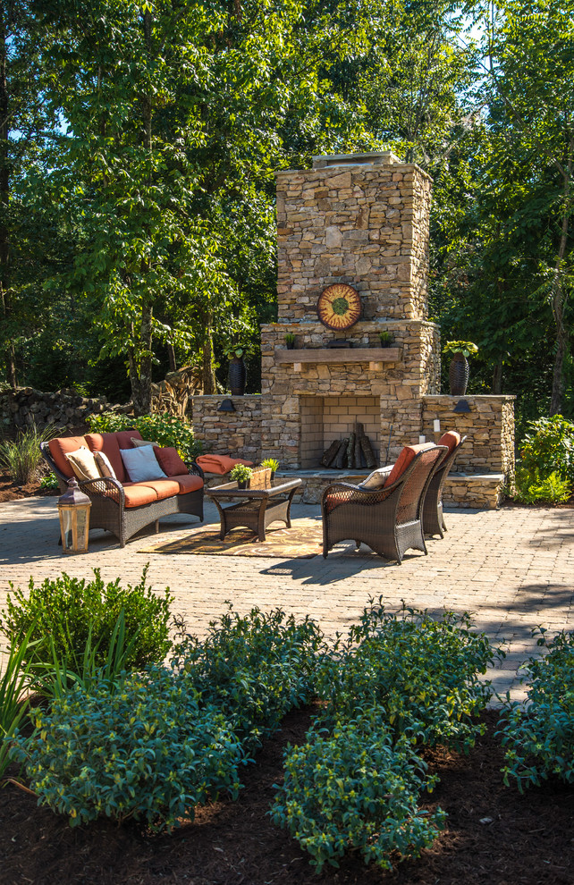 Large country backyard patio in Other with a fire feature, concrete pavers and no cover.