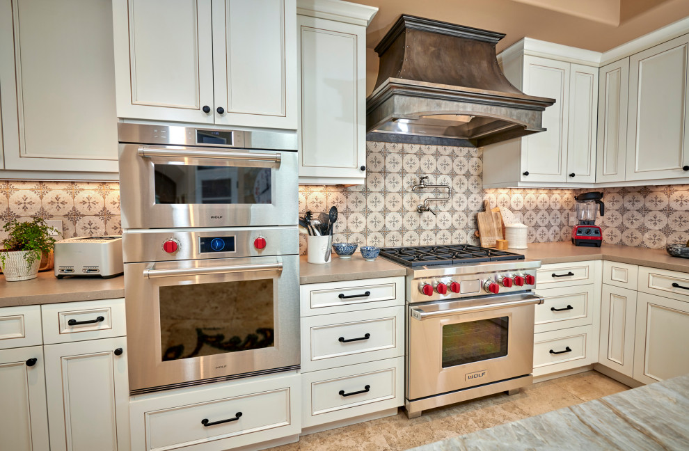 Inspiration for a mid-sized rustic galley travertine floor, beige floor and exposed beam open concept kitchen remodel in Denver with a farmhouse sink, recessed-panel cabinets, white cabinets, quartz countertops, multicolored backsplash, stone tile backsplash, stainless steel appliances, an island and brown countertops