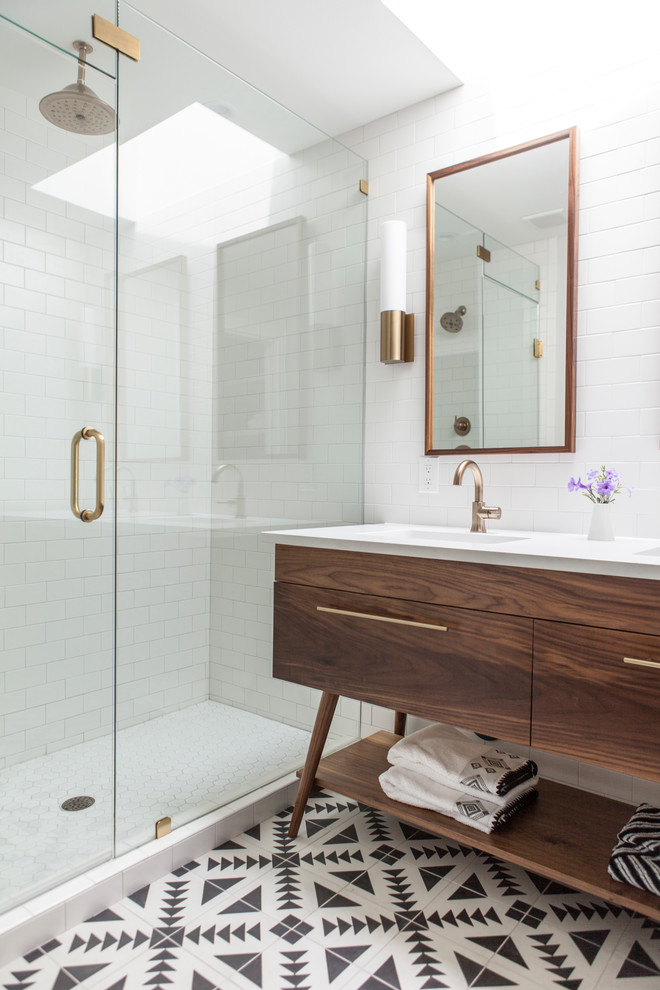 Inspiration for a contemporary master bathroom in Austin with medium wood cabinets, an alcove shower, white tile, subway tile, white walls, an integrated sink, multi-coloured floor, a hinged shower door, white benchtops and flat-panel cabinets.