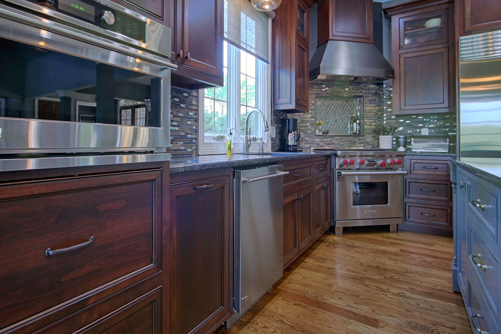 Eat-in kitchen - large transitional medium tone wood floor eat-in kitchen idea in Charlotte with an undermount sink, flat-panel cabinets, stainless steel appliances and an island