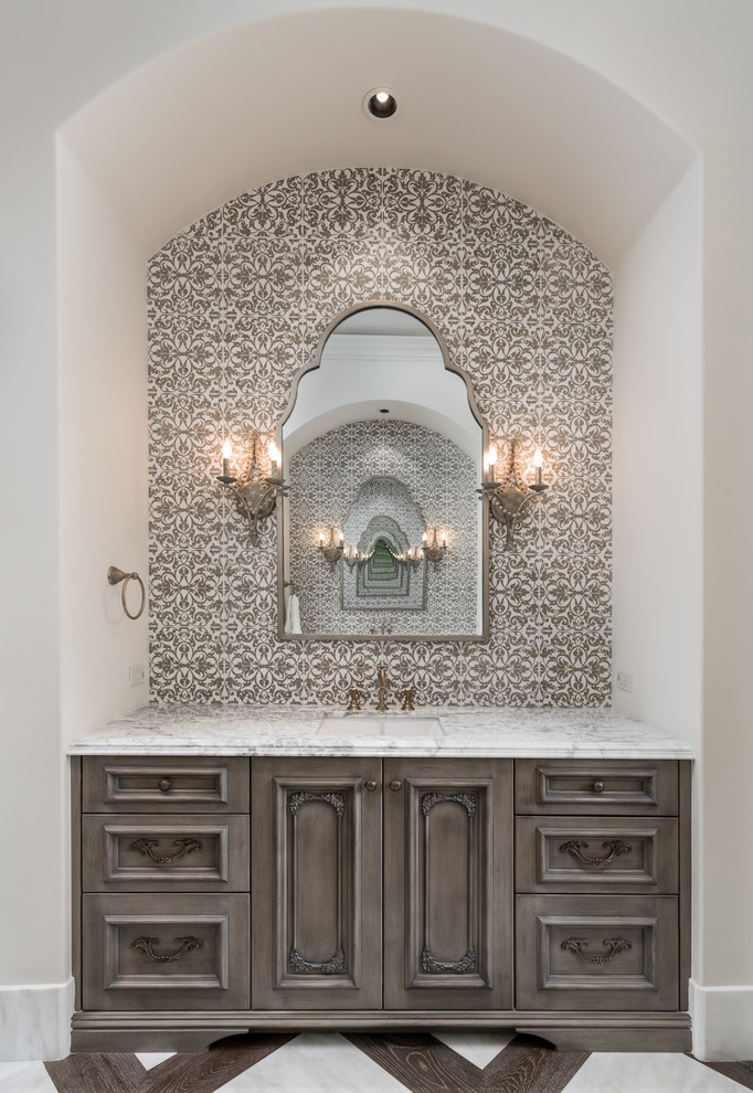 Design ideas for a mid-sized mediterranean master bathroom in Phoenix with brown cabinets, brown tile, ceramic tile, white walls, dark hardwood floors, a drop-in sink, marble benchtops, brown floor, white benchtops, a single vanity, a built-in vanity and vaulted.