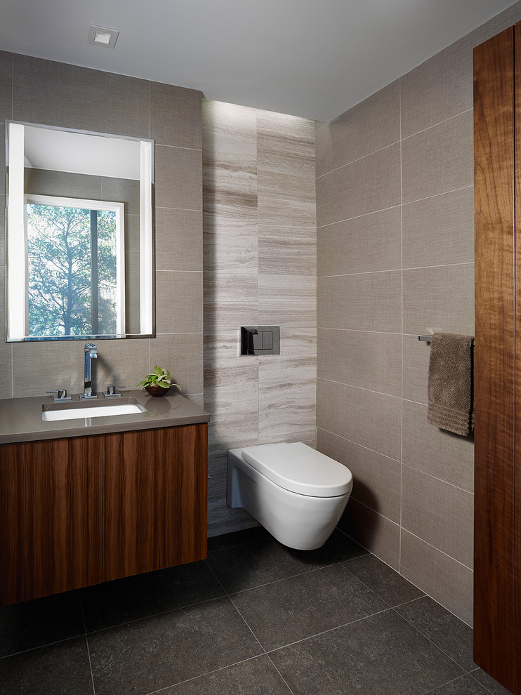 Inspiration for a contemporary bathroom in Philadelphia with an undermount sink, flat-panel cabinets, dark wood cabinets, a wall-mount toilet, gray tile, engineered quartz benchtops, porcelain floors and grey benchtops.