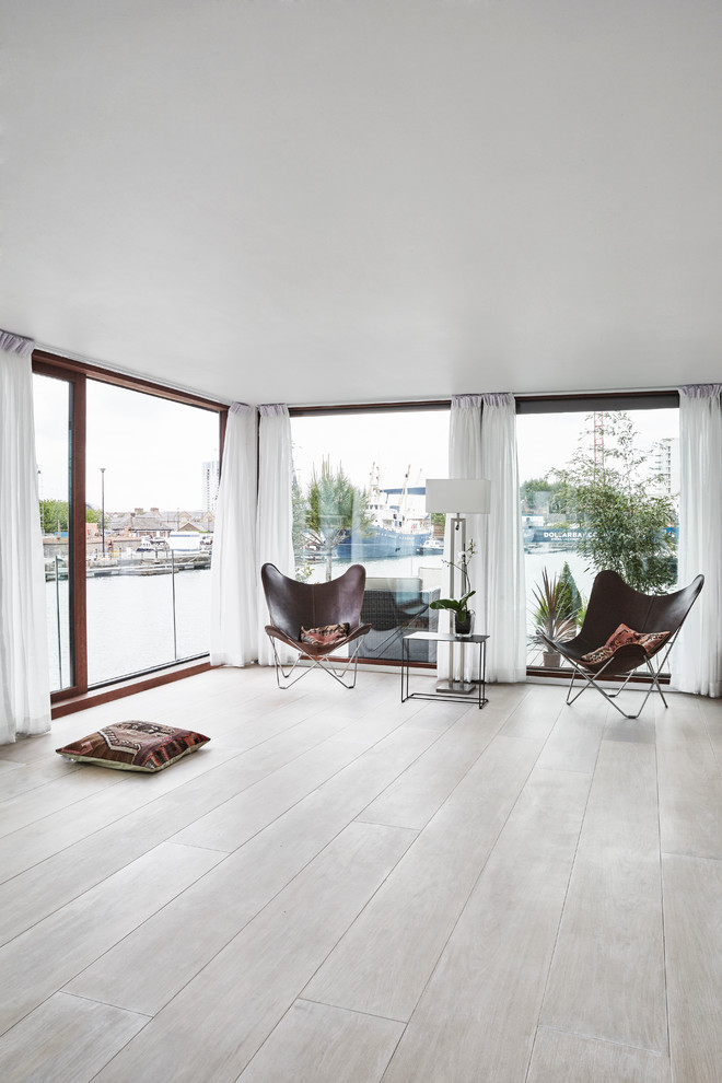 Large open concept family room in Copenhagen with white walls, no tv and grey floor.