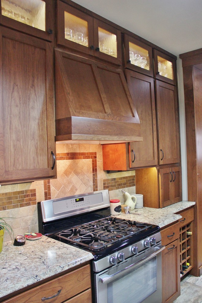 Mid-sized transitional galley ceramic tile enclosed kitchen photo with an undermount sink, shaker cabinets, medium tone wood cabinets, quartz countertops, beige backsplash, stone tile backsplash, stainless steel appliances and a peninsula