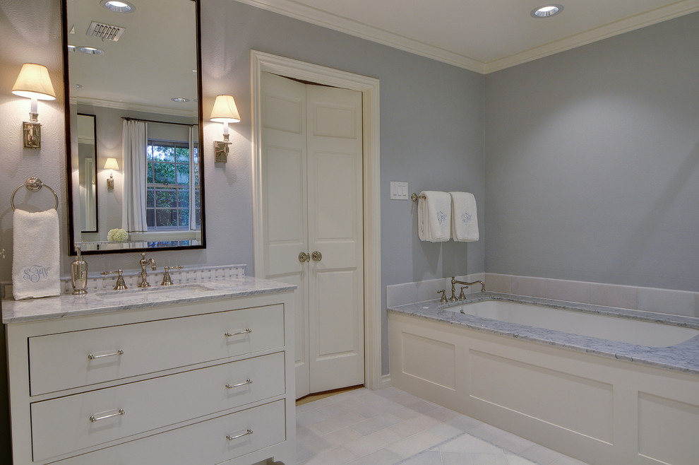 This is an example of a large transitional master bathroom with flat-panel cabinets, white cabinets, an alcove tub, a corner shower, a two-piece toilet, gray tile, stone tile, grey walls, ceramic floors, an undermount sink and engineered quartz benchtops.