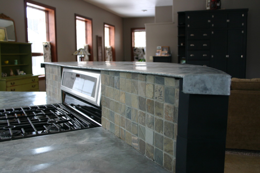 Inspiration for a mid-sized transitional l-shaped concrete floor eat-in kitchen remodel in Orange County with shaker cabinets, black cabinets, concrete countertops, multicolored backsplash, stone tile backsplash, stainless steel appliances and an island