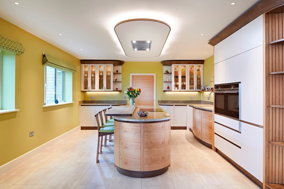 На фото: угловая кухня среднего размера в современном стиле с обеденным столом, плоскими фасадами, фасадами цвета дерева среднего тона и островом с