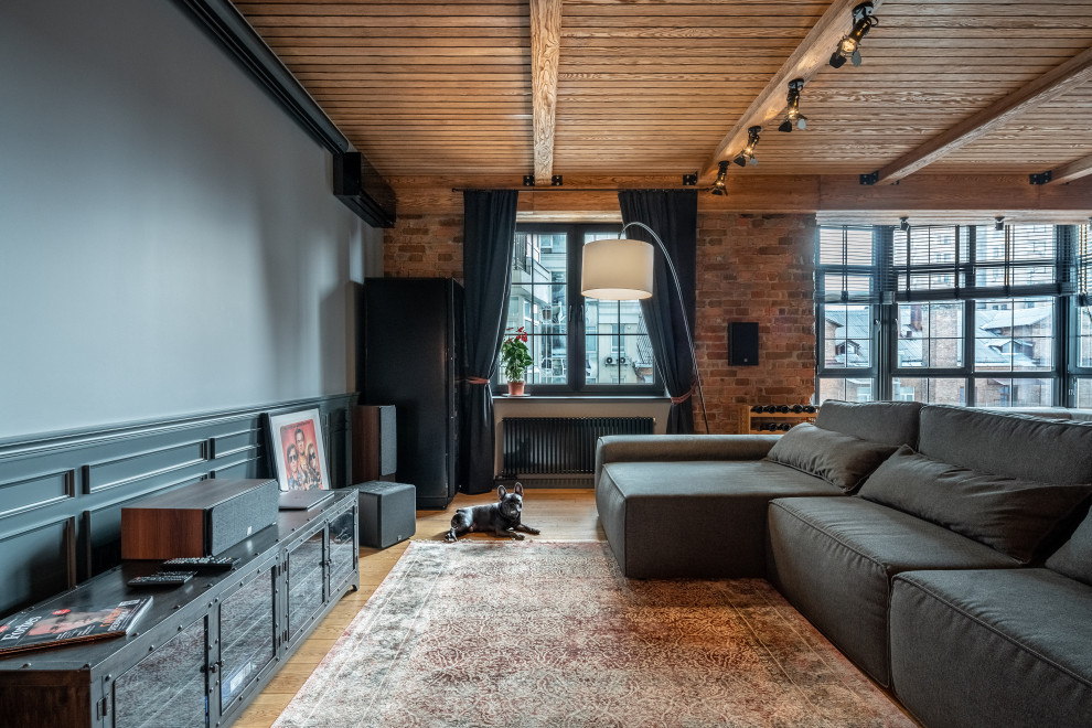 Inspiration for an industrial open concept medium tone wood floor, brown floor, exposed beam, wood ceiling, brick wall and wainscoting living room remodel in Other with gray walls